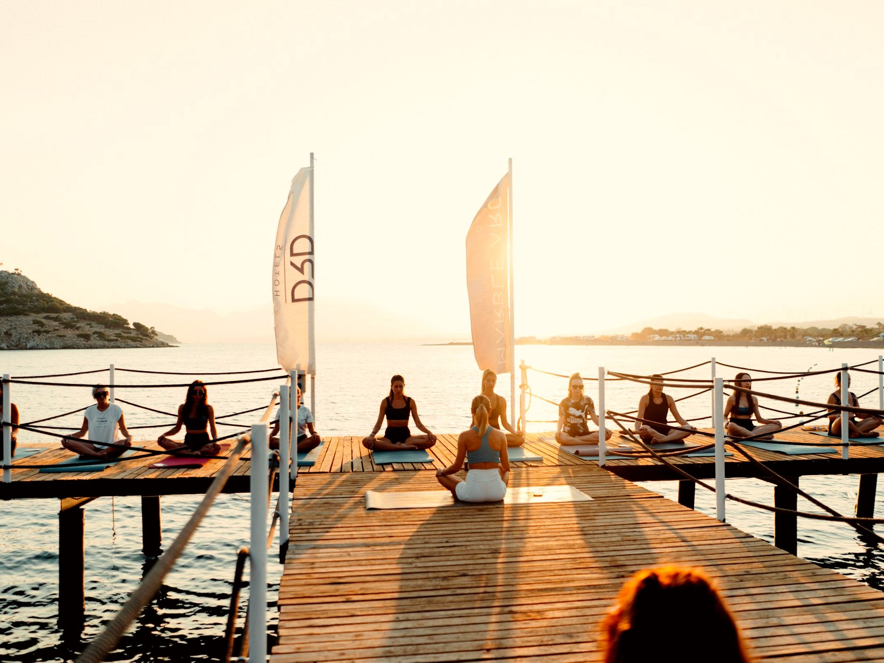 A sunrise yoga class on a resort dock over the water