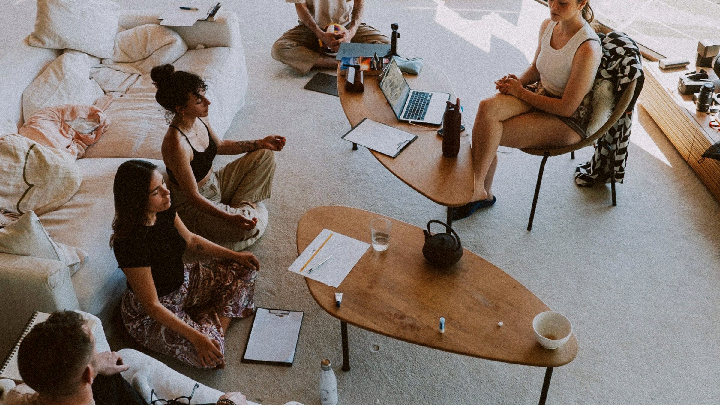 A group meditating together in a bright room