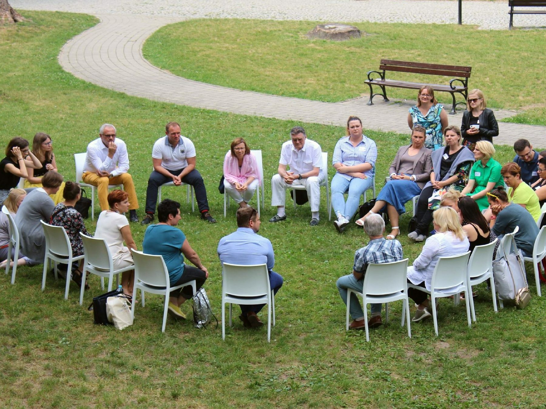 A circle of chairs on the grass for a facilitated session